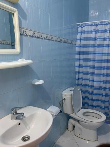 a blue bathroom with a toilet and a sink at Zellaka apartamento2 in Asilah