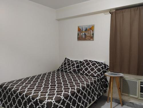 a bedroom with a black and white bed and a window at Confortable Apartamento in Maracaibo