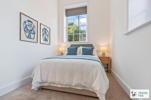 a white bedroom with a bed and a window at The Old Chapel in Dilhorne