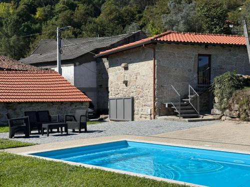 a house with a swimming pool in front of it at Casa da Cancela - Piscina & Jacuzzi - Gerês in Terras de Bouro
