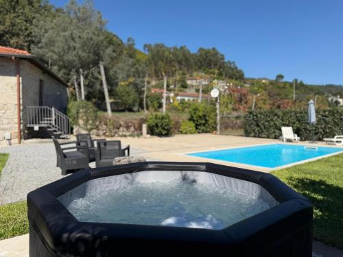 a swimming pool with a hot tub next to a swimming pool at Casa da Cancela - Piscina & Jacuzzi - Gerês in Terras de Bouro