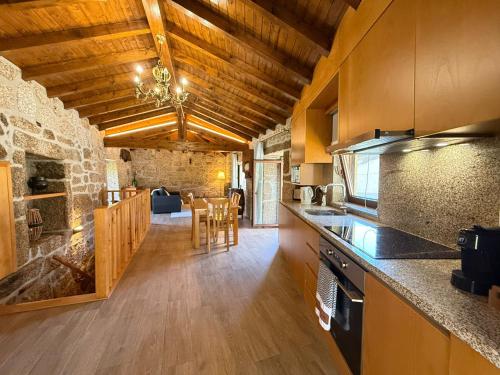 a kitchen with a counter and a dining room at Casa da Cancela - Piscina & Jacuzzi - Gerês in Terras de Bouro