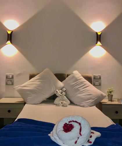 a stuffed teddy bear sitting on a bed with pillows at Downtown Cairo Calma in Cairo