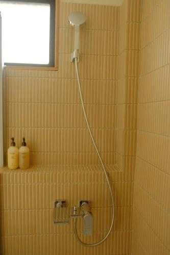 a shower in a bathroom with a shower head at Tomo 伴 in Tainan