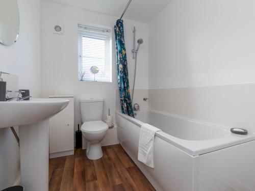 a white bathroom with a toilet and a sink at Pass the Keys Modern Office Driveway Near Crok Durham in Willington