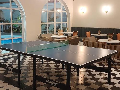 a ping pong table in a room with tables and chairs at Santé Vivre L'expericénce, Búzios in Búzios