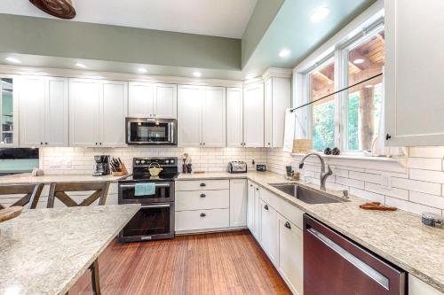a kitchen with white cabinets and a sink at Nesting in North Creek in North Creek