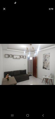 salon z kanapą i stołem w obiekcie kitnet encantadora no centro de Campina Grande -PB - APT 302 w mieście Campina Grande
