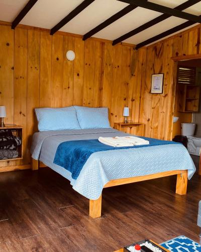 a bedroom with a bed in a wooden room at Villa De Los Sueños in Pasto