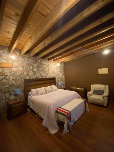 a bedroom with a bed and a chair at Aldea Lea Tapalpa 