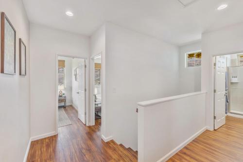 an empty living room with white walls and wood floors at Kalo Homes - Tropical Makaha Sanctuary in Makaha Valley