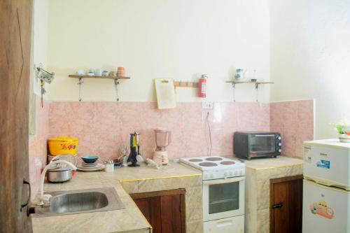 a small kitchen with a sink and a stove at Low budget double room in Paje in Paje