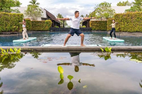 a man and two women on paddle boards in the water at Marriott Vacation Club, Khao Lak Beach Resort in Khao Lak
