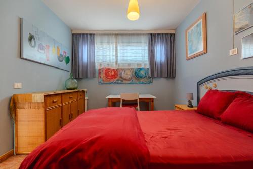 a bedroom with a red bed and a table at Artcorner, POOL & WIFI in Costa Del Silencio