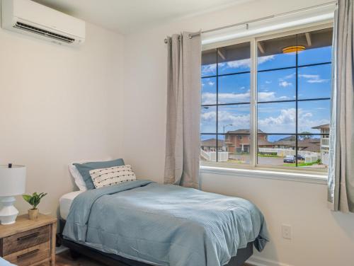 a bedroom with a bed and a large window at Kalo Homes - Surfside Serenity in Makaha Valley