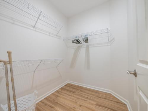 a white room with white shelves and a wooden floor at Kalo Homes - Surfside Serenity in Makaha Valley