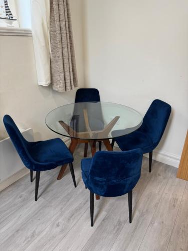 a glass table with two blue chairs and a glass table at Unit 4 Tranquil Harbourside Retreat- Central Location in Cobh