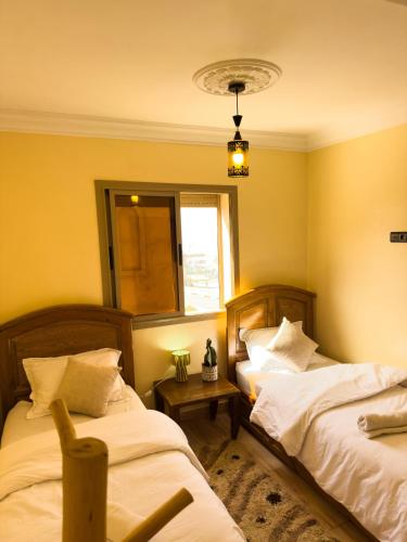 a bedroom with two beds and a window at Imsouane Vibe Surf house in Imsouane
