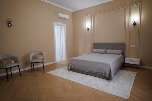 a bedroom with a bed and two chairs at Citadelle house in Alba Iulia