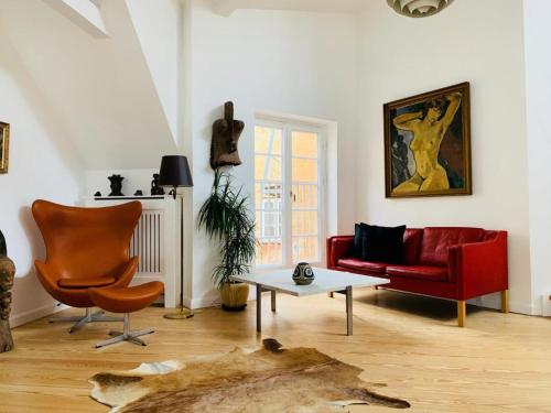 a living room with a red couch and a table at Luxury apartment in the heart of Copenhagen in Copenhagen