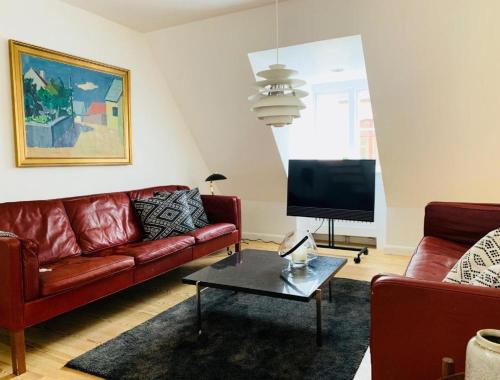 a living room with a red couch and a tv at Luxury apartment in the heart of Copenhagen in Copenhagen