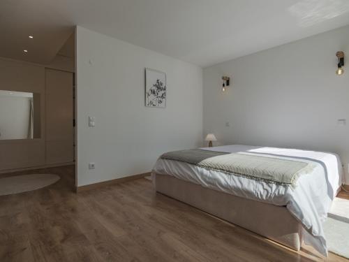 a white bedroom with a bed and a television at Dom Carlos Villa in Vila Nova de Gaia