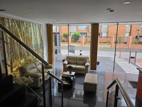 a living room with couches and chairs in a building at Hotel Castellana 100 Bogota By Hoteles Confort 80 in Bogotá