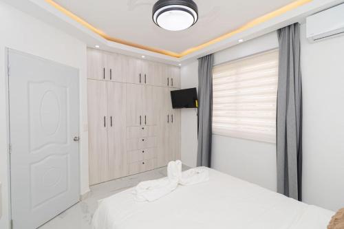 a bedroom with a white bed and a window at Cozy 1BR 1BA Bayahibe Getaway with Pool in Bayahibe