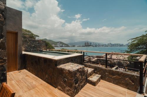 a jacuzzi tub on a balcony overlooking the water at Perla Roca Hotel Boutique - Beach Front in Santa Marta