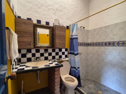 a bathroom with a sink and a toilet and a mirror at Casa Campestre El refugio in Girón