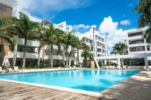 una piscina frente a un gran edificio en Stylish 1BR Condo in the Heart of Bayahibe w Pool, en Bayahibe