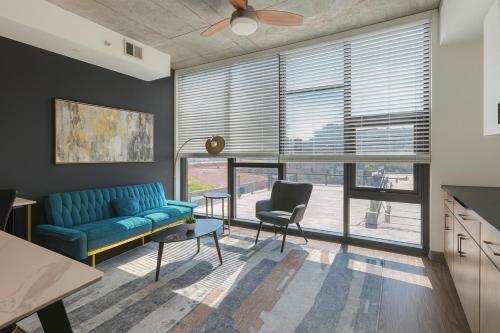 a living room with a blue couch and a chair at Stylish 2BR Rooftop Views plus Sky Lounge in Birmingham