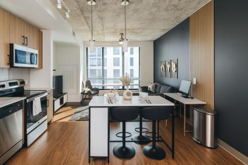 a kitchen and living room with a white island in a room at City Escape 2BR Apt with Resort Amenities in Birmingham