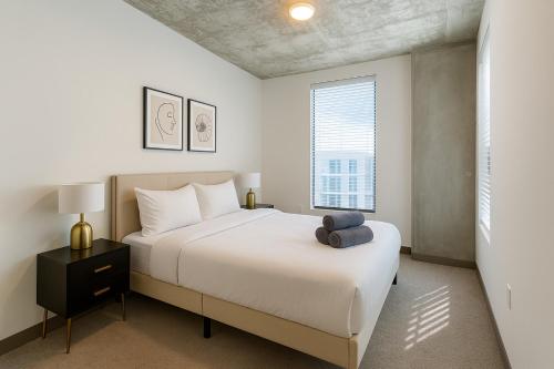 a bedroom with a large white bed and a window at City Escape 2BR Apt with Resort Amenities in Birmingham