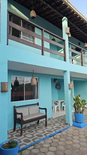 a blue building with a bench on a patio at Pousada Estrela do Norte in Pipa
