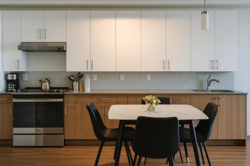 a kitchen with a table with chairs and white cabinets at Upscale 2BR Apt Rooftop Deck and Fitness in Birmingham