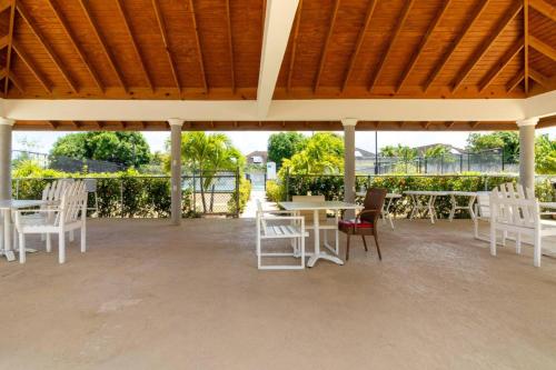 a patio with white chairs and tables and a wooden roof at 3rd Floor Condo wMountain Views - Beach Access - Pool) in Richmond