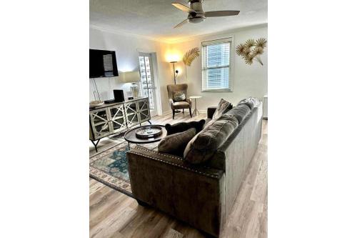 a living room with a couch and a ceiling fan at World Cup 18K City View Condo Near Stadium in Atlanta