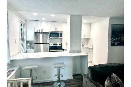 a kitchen with white cabinets and stainless steel appliances at World Cup 18K City View Condo Near Stadium in Atlanta