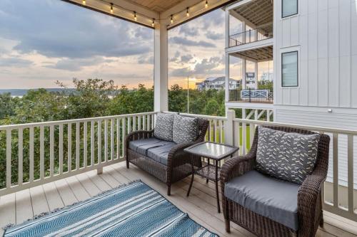 a screened porch with two chairs and a table at Shore Enough, Carlton Landing Lakeview in Carlton Landing