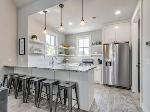 a kitchen with white cabinets and a stainless steel refrigerator at Shore Enough, Carlton Landing Lakeview in Carlton Landing