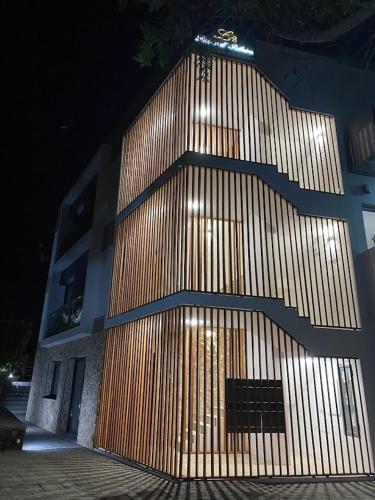 a building with a wooden wall with a bench in front at Lugar d ribeira in Lagoa