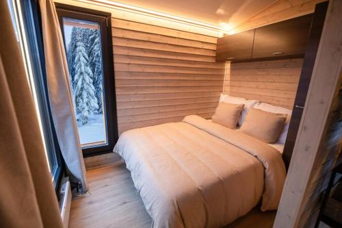 a bedroom with a bed in a room with a window at Compact Cabin for Remote Work and Adventures in Yllas in Ylläsjärvi