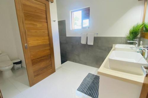 a bathroom with a sink and a toilet at Bonita Beach Villa in La Ceiba