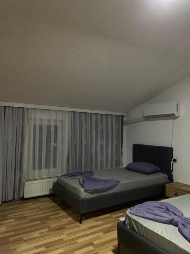 a bedroom with two beds and a window at Dragovca Apartment in Prizren
