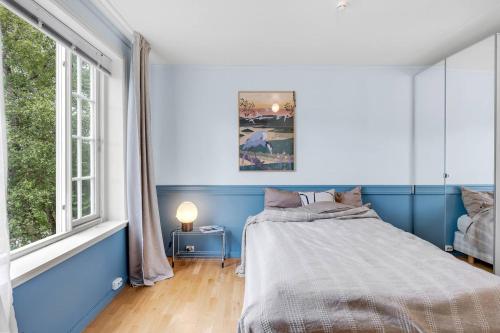 een blauwe slaapkamer met een bed en een raam bij Arctic hilltop lodge - Room 4 in Guleng