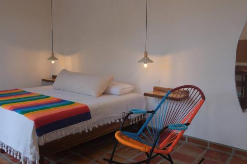 a bedroom with a bed and a rocking chair at Sayulita beach-side studio 2 by CasasTropical in Sayulita