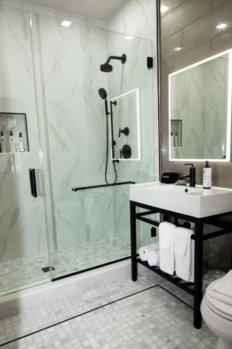 Un baño con ducha, lavabo e inodoro. en The Key West Hotel, en Key West