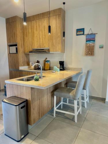 a kitchen with a sink and a counter with chairs at Casa Tortuga Cabo Paradise in Cabo San Lucas