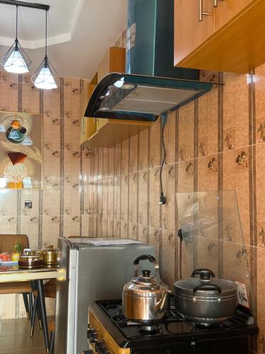 a kitchen with a stove with pots and pans on it at AAgift Apartments in Ibadan